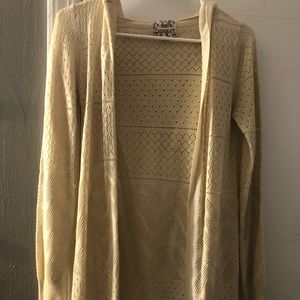 a cream colored cardigan with cut out details